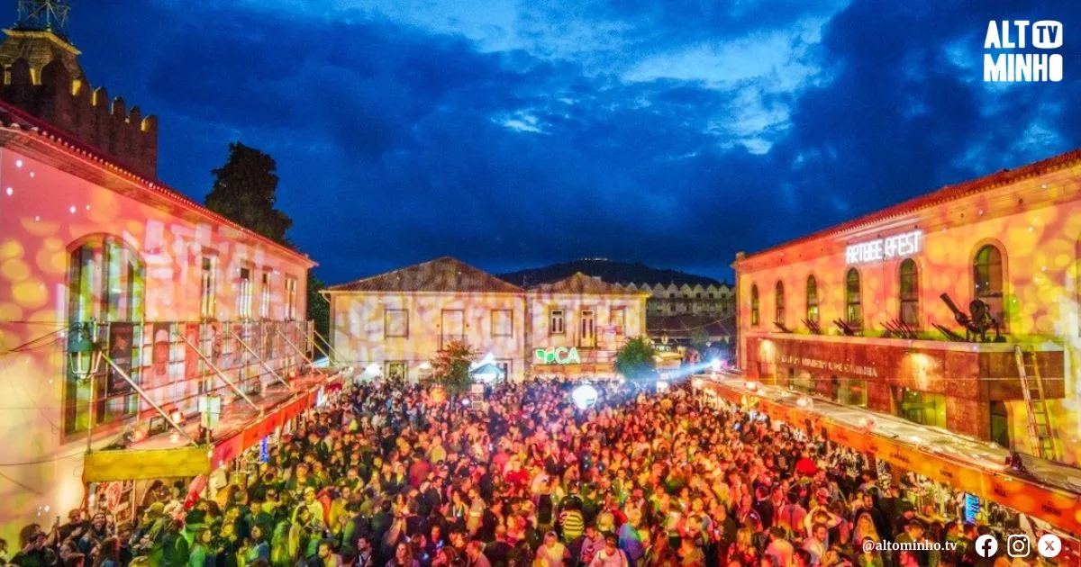 Vista aérea noturna do ArtBeerFest, com multidão nas ruas e edifícios iluminados